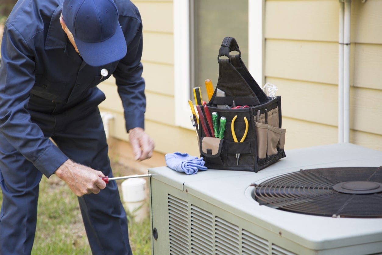 Electrician checking an outdoor air conditioner unit